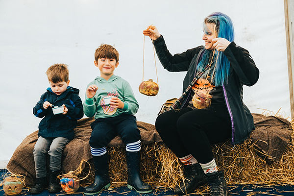 A family sat on hay bails at Hop tu Naa festival on the Isle of Man
