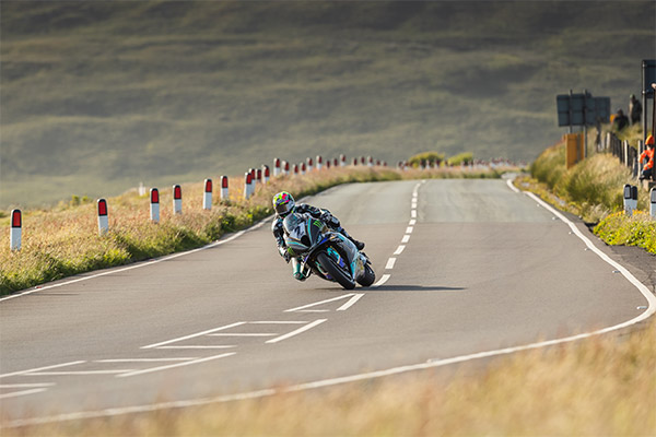 Someone on a motorbike taking a wide corner during the TT on the Isle of Man