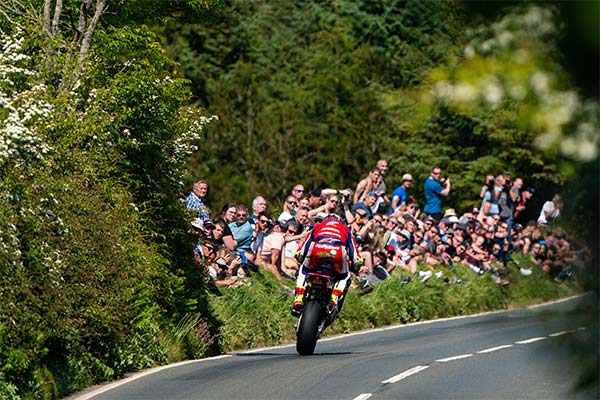 John McGuiness racing past a crowd of people watching the Isle of Man TT